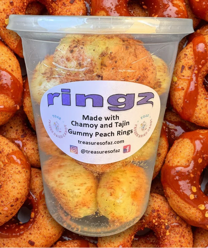 Container of chamoy and tajin gummy peach rings with spicy candy coating background