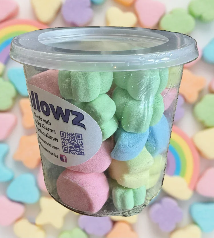 Tub of colorful freeze-dried marshmallows with pastel candy hearts and rainbows in background