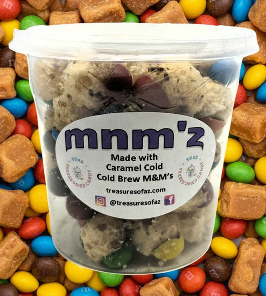 Container of freeze-dried caramel cold brew candy M&M's on colorful candy and caramel background