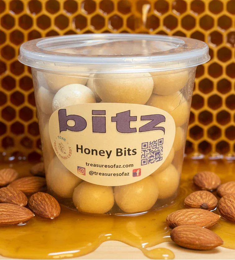Container of honey bits candies with almonds, honeycomb, and honey in the background