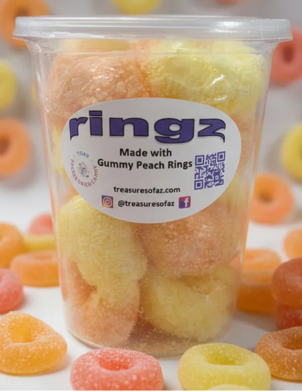 Clear cup filled with yellow and orange gummy peach rings, label reads 'ringz'.